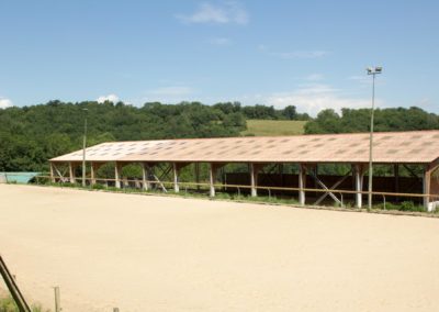 La carrière et le manège en arrière-plan - Les Écuries du Vallon